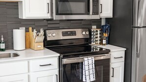 Eine moderne Küche mit Edelstahlgeräten, einer Mikrowelle, einem Backofen und einem Kühlschrank.