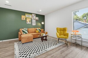 Ein Wohnzimmer mit Sofa, Sesseln und einem gemusterten Teppich.