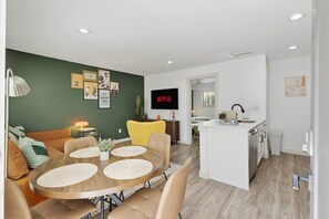Eine moderne Wohnung mit Essbereich, Küche und Wohnzimmer.
