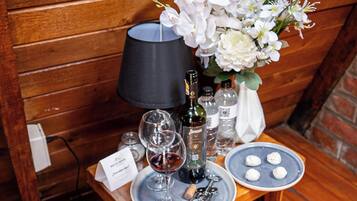 Une table en bois avec une bouteille de vin, des verres, une bougie et une assiette de nourriture.
