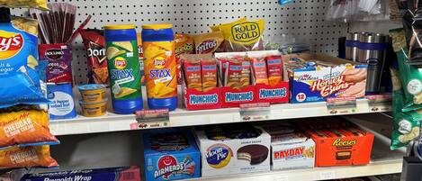 Een gangpad in een supermarkt met diverse snacks en snoep.