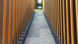 A corridor with wooden slats on the walls and a tiled floor. - New, Fully Furnished Apartment in Guadalajara-Zapopan with AC and Pool—Pet-Friendly (Guadalajara)