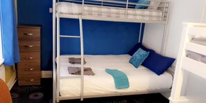 A bunk bed with a ladder, a wooden dresser, and a blue wall. - Bloomfield Lodge Hotel (Blackpool)