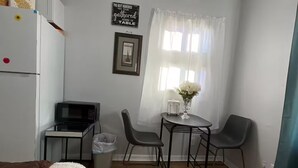 Un espacio habitable compacto con kitchenette, comedor y zona de estar.