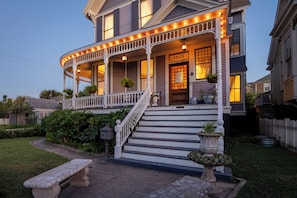 A two-story house with a porch, a staircase, and a front door.