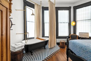 Une salle de bain avec une baignoire, un banc en bois et un carrelage à carreaux.