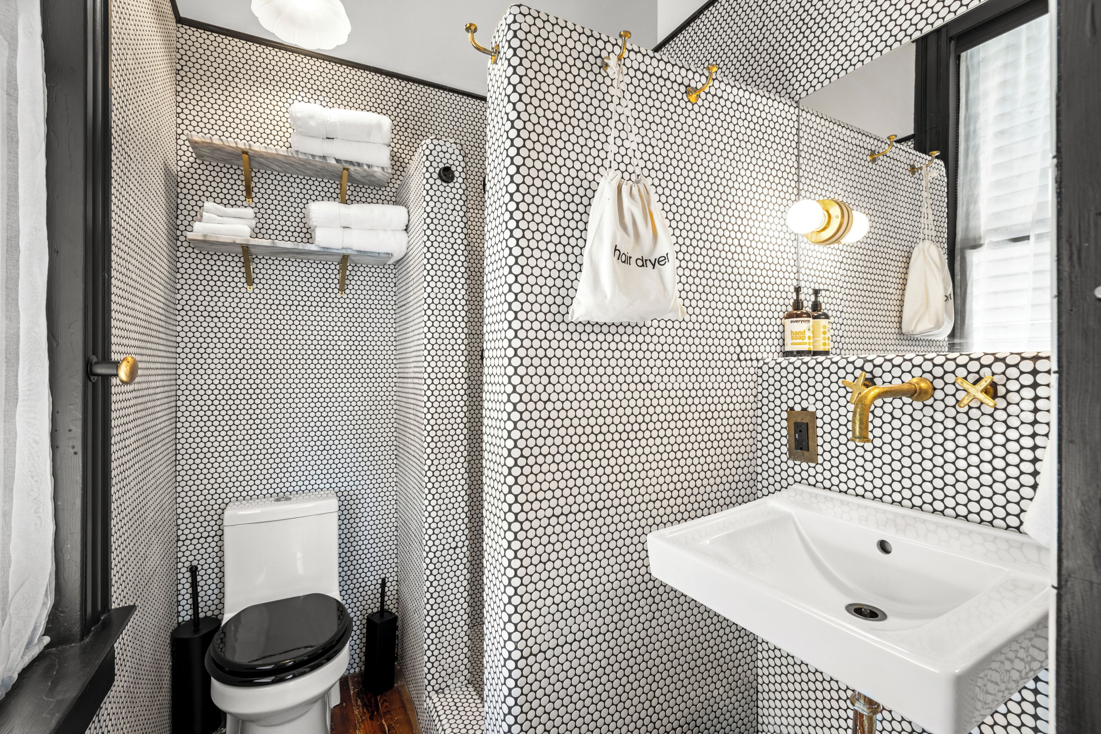 Un baño con inodoro, lavamanos y perchero para toallas.