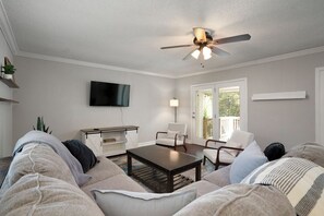 Ein Wohnzimmer mit Sofa, Couchtisch und Deckenventilator.