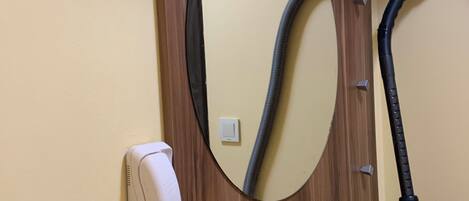 Un escritorio de madera con un teléfono y un espejo.