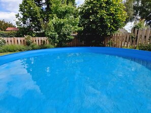 A clear blue swimming pool surrounded by a wooden fence and lush greenery. - Lovely house with a garden and pool in Österlen – Villa Harmoni (Löderup)