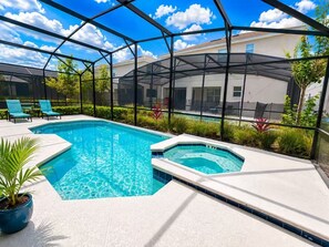 A pool with a hot tub, surrounded by a covered patio with chairs and plants. - 24BR Family Resort  Two Luxury Villas Near Disney (Kissimmee)