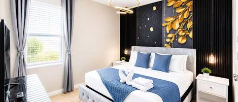Une chambre moderne avec un lit capitonné, une grande fenêtre avec des rideaux, un luminaire fixé au mur et un motif décoratif en forme de feuilles sur le mur.