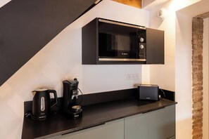 A modern kitchen with a Bosch microwave, a coffee maker, and a toaster on a black countertop. - The Ostalet in Sampzon  (Sampzon)