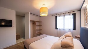 A bedroom with a bed, a TV, a wardrobe, and a window. - The Ostalet in Sampzon  (Sampzon)