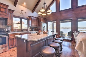 Una cocina amplia con una isla grande, armarios de madera y vista a una masa de agua.