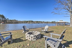 A lakeside seating area with Adirondack chairs, a stone fire pit, and a gazebo. - The Firefly House at Selah Manor- BIG Lake Views on all sides of the House! (Shelby)