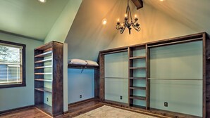 A loft bedroom with a bunk bed, built-in shelving, and a chandelier. - The Lighthouse at Selah Manor- BIG Lake Views on all sides of the House! (Shelby)