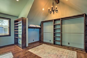 A loft bedroom with a bunk bed, built-in shelving, and a chandelier. - The Lighthouse at Selah Manor- BIG Lake Views on all sides of the House! (Shelby)