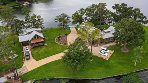 A residential area with two houses, a dock, and a boat. - The Lighthouse at Selah Manor- BIG Lake Views on all sides of the House! (Shelby)