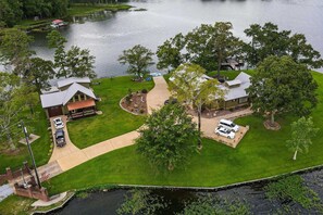 A residential area with two houses, a dock, and a boat. - The Lighthouse at Selah Manor- BIG Lake Views on all sides of the House! (Shelby)