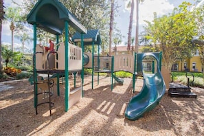 Ein Spielplatz mit Rutsche, Klettergerüsten und einem überdachten Bereich.