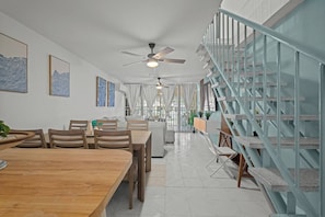 A modern interior with a dining area, a staircase, and a ceiling fan. - Beachside Villa Dorado Pool Beach Access (Dorado)