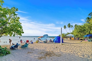 A beach with people, tents, and umbrellas. - Beachside Villa Dorado Pool Beach Access (Dorado)