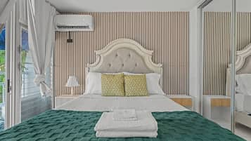Un dormitorio con cama, lámpara de noche, aire acondicionado y un espejo grande.