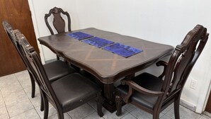 A dining table with four chairs, a tiled floor, and a door in the background. - Large and private 3 bedroom and 2 bathroom apartment, separate street entrance (Perth Amboy)