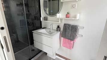 Een douche, handdoeken, toiletpapier