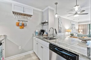 Eine moderne Küche mit Geschirrspüler, Kaffeemaschine und Weinkühlschrank.