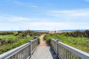 A wooden boardwalk leading to a beach with a clear sky. - Ocean Creek Lodge 1 2422 - Beach, Pools, Hot Tubs (Myrtle Beach)