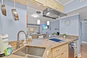 Eine moderne Küche mit Granit-Arbeitsplatten, Edelstahlgeräten und einem eingebauten Backofen.