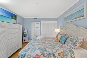 Ein Schlafzimmer mit Bett, Kommode und Meerblick.