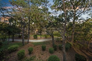 A park with trees, a pathway, and a building in the background. - Ocean Creek Lodge 1 2422 - Beach, Pools, Hot Tubs (Myrtle Beach)