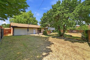 A residential property with a detached garage, a lawn, and mature trees. - Peaceful 4-bedroom house with AC in Colorado Springs (Colorado Springs)