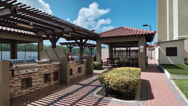 Una terrazza esterna con barbecue, posti a sedere e vista sul lago.