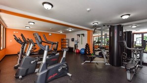 Una palestra con tapis roulant, macchinari per pesi e pesi liberi.