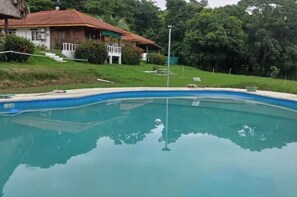 Una piscina con una casa al fondo.
