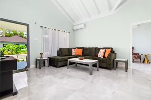 A modern living room with a sectional sofa, two side tables, and a coffee table. - DraxHall~3BR~Poo ~Beach Access - 24hr Security (St. Ann's Bay)