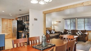 Une cuisine équipée d’un réfrigérateur, d’une cuisinière et d’un coin repas avec des chaises et une table.