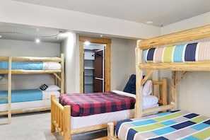 A room with bunk beds, a closet, and a door leading to another room. - Mountain Getaway • Hot Tub • Game Room • Sleeps 10 • Minutes to Payette Lake (McCall)
