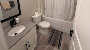 Une salle de bain avec un lavabo, des toilettes et une baignoire.