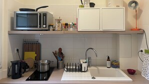 Eine Küche mit Mikrowelle, Kaffeemaschine und Spüle.