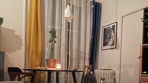Ein gemütliches Wohnzimmer mit Holzboden, einem runden Couchtisch, einer Couch und einem Esstisch.
