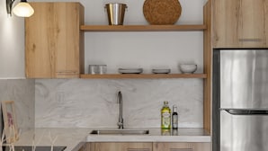 Uma cozinha moderna com armários de madeira, geladeira de aço inoxidável e bancada de mármore.