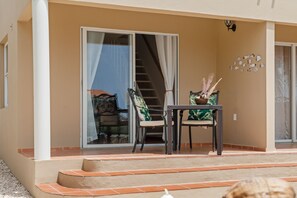 Ein Balkon mit Tisch und Stühlen, eine Treppe und eine Wand mit Fischornamenten.