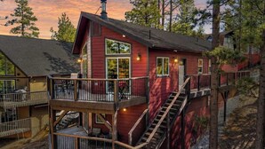 A red cabin with a balcony and a staircase leading to a second level. - Hilltop Cabin | Fireplace - Games - Views (Big Bear)