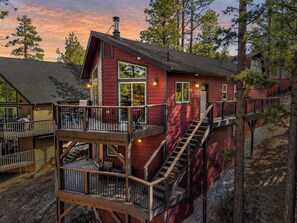 Eine rote Holzhütte mit einem Balkon und einer Treppe zu einer zweiten Ebene.