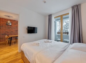 Une chambre d’hôtel équipée d’un lit, d’une télévision, d’un bureau et offrant une vue sur l’extérieur.